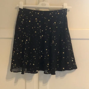 Kjol från Mint and berry  - Svart kjol i två lager med guldiga stjärnor. Storlek saknas men det är en Xs-S. Köpt på Plick men i fint skick och har aldrig använts av mig.