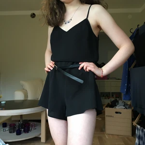 Svart byxdress - Svart byxdress med öppen rygg. I fint skick. 🖤 Justbara axelband, stängs med dragkedja i sidan. Märkt som en 38, skulle nog även passa en 36. Modellen bär ofta 34. Skärpet ingår ej.