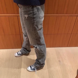 Grå jeans med hål - Svin snygga mid rise grå jeans med hål, skit snygga till hösten. Bra längd då jag är ca 172 och går ner hela vägen till marken plus lite till. Säljer då dom inte kommit till användning. Köpte för 950kr så därför startar den på sånt högt pris. Köpare står för frakt, 66kr.