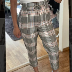 River island kostymbyxor EUR 36/small  - Rutiga kostymbyxor med fickor framtill, tjockt resår upptil och bälte. Väldigt högmidjade och bekväma. Det rutiga mönstret skiftar i färg mellan rosa, blått, vitt, oranget och svart. Använd fåtal gånger. Jag är 167cm. Frakt ingår🌸