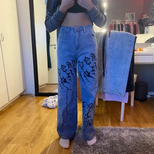 Stora ljusblåa jeans! - Jätte fina ljusblåa jeans med svart Grafitti. Köpta från SHEIN för ungefär 200kr, använda 1 gång. Bra material. Modellen är 1.69 lång.