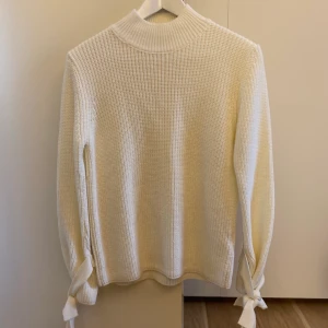 Vit stickad halvpolo GinaTricot XS - Säljer min vita stickade halvpolo från Gina Tricot i storlek XS. Tröjan har snörning i slutet på ärmarna. Sparsamt använd, inget att anmärka på.   Köparen betalar frakten, jag bjuder på emballaget.