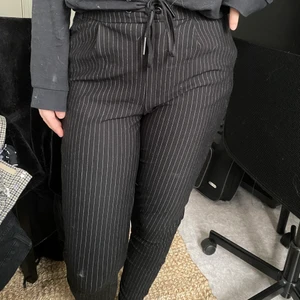 Randiga kostymbyxor med knyte!  - Snygga svarta kostymbyxor med vita linjer! Supersköna med snöre i midjan! Storlek M eller lite lösare passning så passar det S med! Bra skick! Köparen står för frakten (66kr) 🥰! Hårar av och tvättar självklart innan det säljs!! 🐱