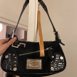 Svart väska - Svart väska från Guess. Strass i G. Flera fack med dragkedjor. Inga fläckar eller hål. Skriv vid funderingar! 🙌🏽