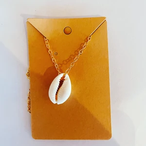 Halsband  - Halsband med guldkedja och en snäcka.