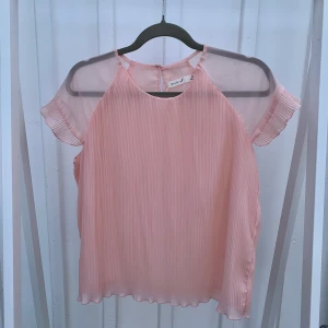 En ljusrosa blus - En fin ljusrosa blus som endast använts ett par gånger. 