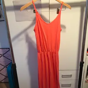 Lång orange sommar klänning. Säljer då den är för lång för mig. Slits detalj i högra benet.