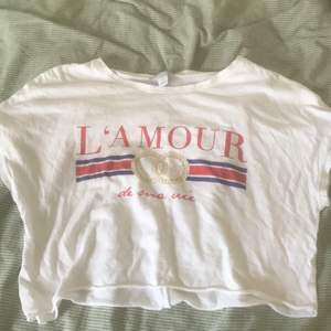 Vit t-shirt som det står ”L’AMOUR” på!