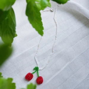 Pärlhalsband ”Körsbär” - KÖRSBÄR är ett pärlhalsband som är ca 38cm långt. Den har en karbinhake som håller ihop smycket.