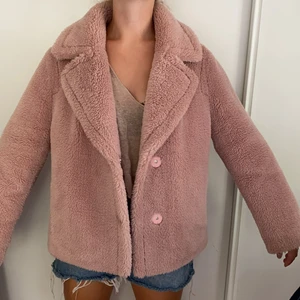 Jacka - Jättefin Stand jacka i Teddy material. Varsamt använd och i jättebra skick. Jackan ser mindre rosa ut på bilderna men är starkare rosa i verkligheten! 