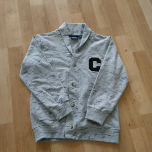 Grå kofta 122/128 - Oanvänd kofta med knappar. 