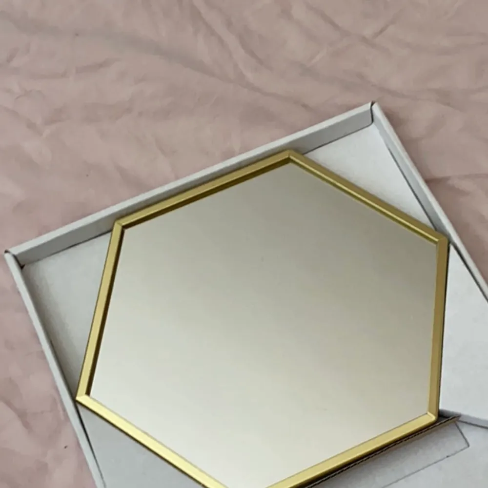 Guldig liten spegel från Ikea. Finns möjlighet att stå upp samt hänga på vägg med kedja.. Övrigt.
