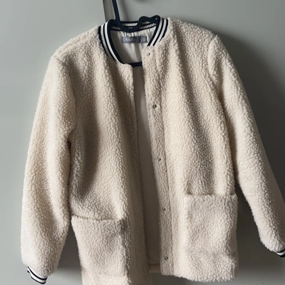 En fake ull jacka ifrån Åhléns. Aldrig kommit till användning- för liten. Två stora fickor mer mjuk ull. Stängs genom knappar.  Rekommenderas till hösten!!. Jackor.