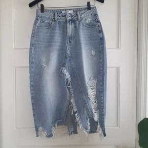 Helt oanvänd knälång jeanskjol - Nyinköpt, oanvänd jeanskjol. 100% bomull, ingen stretch. Hög i midjan och strl L men något liten i storlek. 
