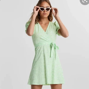 Gina sommarklänning - Säljer denna söta klänning då den tyvärr har blivit för liten för mig. Den är grön blommig med puffärmar och v ring. Köpt för 300 kr säljer nu för hälften. Använd ett fåtal gånger:)