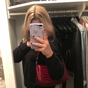 Vinröd skinnväska - Super cool väska som tuvärr inte kommer till användning, så gott som ny. bandet är ca 45 cm, väskan är ca 15 cm lång och ca 25 cm bred. Kan mötas i Eskilstuna eller skickas.