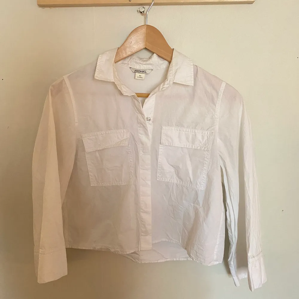 En vit skjorta från Monki i 100% bomull. Fina fickor på framsidan samt härliga vida trekvartslånga ärmar. Använd men i fint skick. . Skjortor.