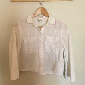 En vit skjorta från Monki i 100% bomull. Fina fickor på framsidan samt härliga vida trekvartslånga ärmar. Använd men i fint skick. 