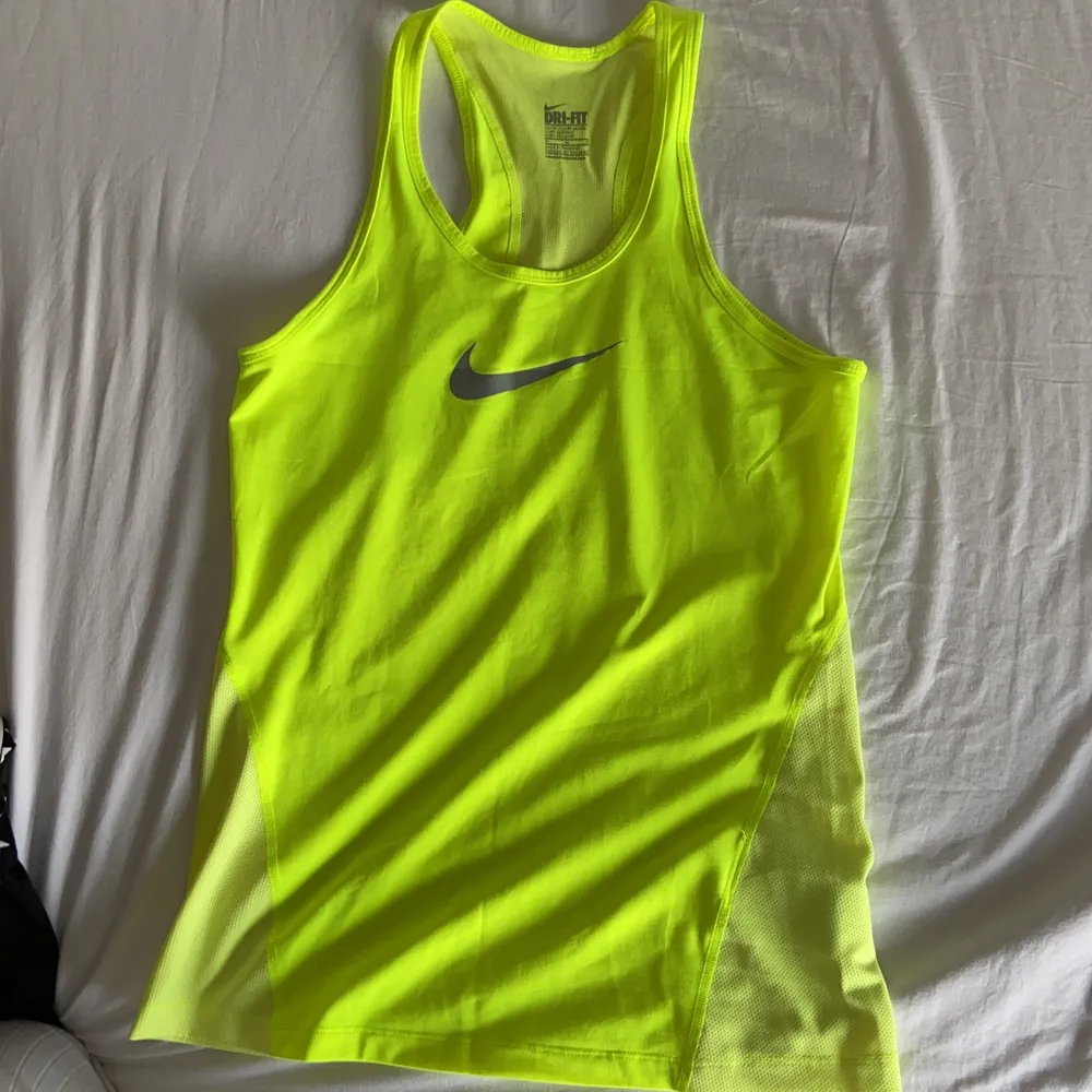 Ett nästan helt oanvänt neongult träningstimmar från Nike.         Säljer pågrund av att det är för stort för mig.              STORLEK M . Toppar.
