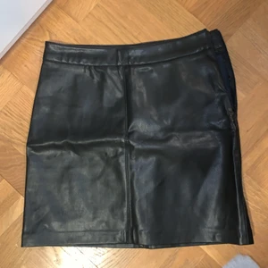 Läder kjol (ej riktigt) storlek 34 från Ginatricot - ”Läder” kjol från ginatricot i strl 34 som är i bra skick och använd 1-2 gånger men nytvättad ❤️