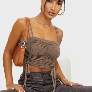 Croptop tunna axelband och rusched i sidan - Oanvänd med prislappar kvar. Stretchig, strl 34 från PrettyLittleThing.