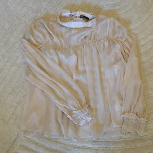 Puderfärgad blus m knytband i nacken - Söt blus i ljuvlig puderfärg med knytband i nacken. Nyskick!