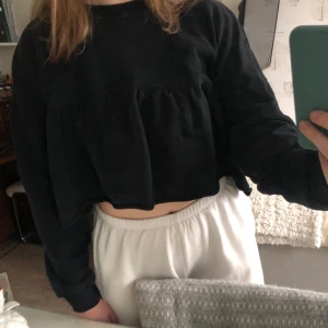 Croppad collagetröja  - Croppad svart collagetröja med volang. Använd fåtal gånger, mycket fint skick. Kan mötas upp eller posta. Köparen står för frakt