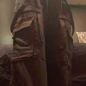 Byxor - Svarta byxor med röda sömmar o mycket detaljer i mycket bra skick! 