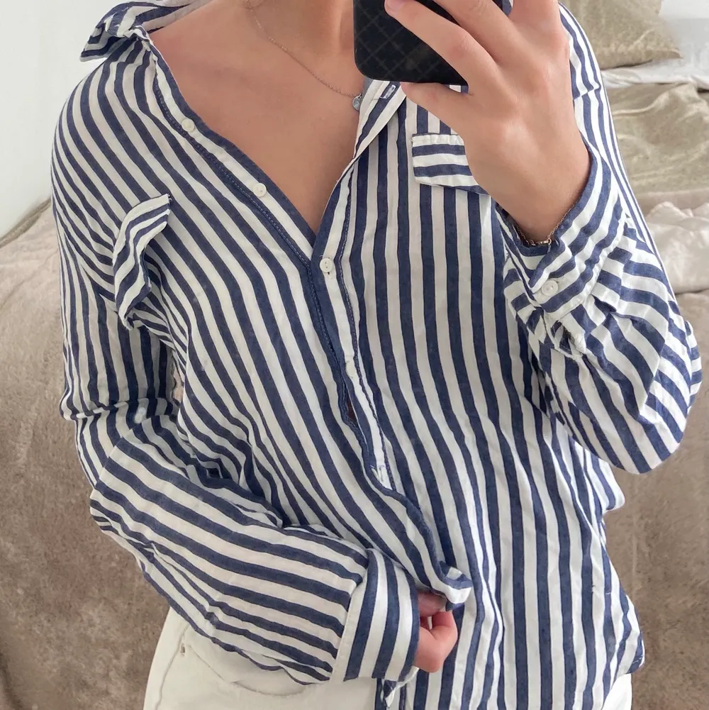 Säljer min blå/vita skjorta perfekt till sommaren men även som ett plagg över bikinin storlek M. Skön och luftig i tunt material, men tyvärr kommer den inte till användning. Frakt tillkommer💙. Skjortor.