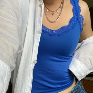 Blått linne - Fint blått linne med spetsdetaljer ovantill. Storlek M men liten i storleken.