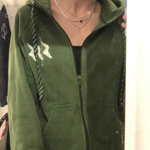 As coolt grön zip up tröja med högre krage och vita detaljer. 