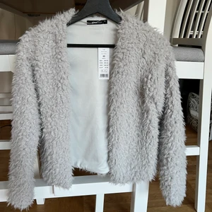 Oanvänd fluffig kofta - En helt oanvänd grå, fluffig kofta från Gina Tricot. Lappen sitter kvar. Väldigt mysig!