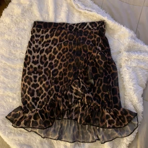 Leo kjoj från NELLY - En snygg kjoj från Nelly, strl xs. Jag är 170cm och den är perfekt längd på mig. Det är en innerkjol så den kan inte blåsa upp vilket är perfekt. Kjolen är knappt använd så den är i väldigt bra skick.🐆🖤Köparen står för frakten