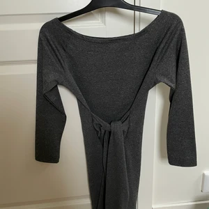 Klänning  - En grå/silvrig klänning, mönstret i klänningen får det att se ut som att den glittrar. Det är som 2 extra amar som man kan knyta i midjan för att markera midjan och som en extra fin detalj.