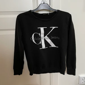 Tröja från Calvin Klein - Långärmad svart tröja från Calvin Klein. Tryck på framsidan.
