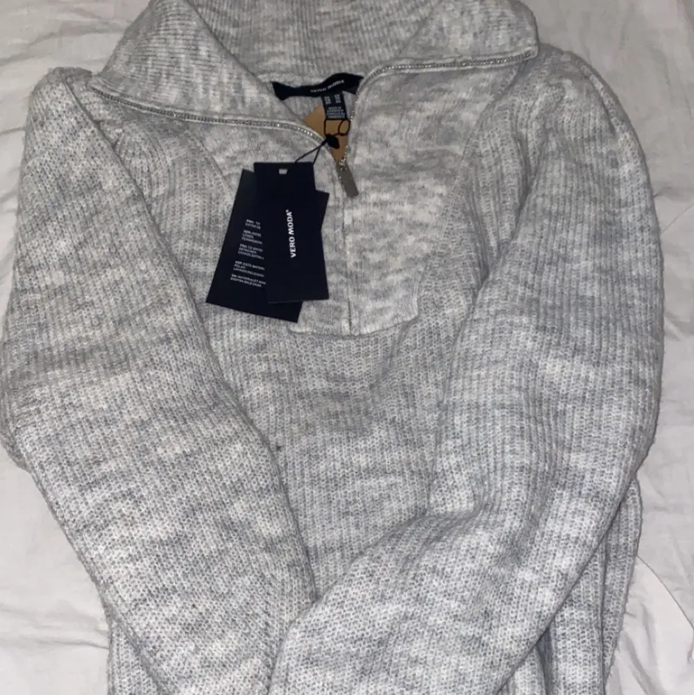 En helt ny grå stickad tröja med dragkedja från Vero Moda. Aldrig använd. Säljs pågrund av att den inte kommit till användning. Väldigt fin och som sagt helt ny. Kan skicka fler bilder om man vill. Stickat.