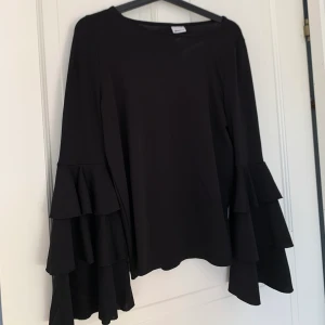 Svart blus med volanger på armarna - 🥰🥰