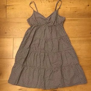 Prickig klänning i grått tyg strl 38 - Är i fint skick. Somrig klänning strl 38. Köparen står för frakt