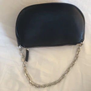 Svart liten väska  - En svart liten väska i fejkskinn med kedje handtag köpt på mango. Används inte eftersom de inte får plats så mycket i den