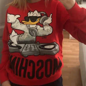 Moschino sweatshirt  - Röd moschino sweatshirt med tryck. Storlek S men stor och passar för M. Aldrig använd. Skriv vid intresse :) fraktkostnad tillkommer, kan dock mötas upp i Stockholm om man inte vill betala frakt :) 