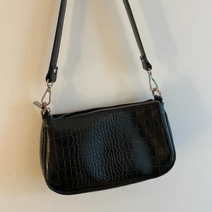 Svart väska - Jättefin svart väska som rymmer mycket! Lite skadad som man ser på bild 2 men annars i väldigt bra skick