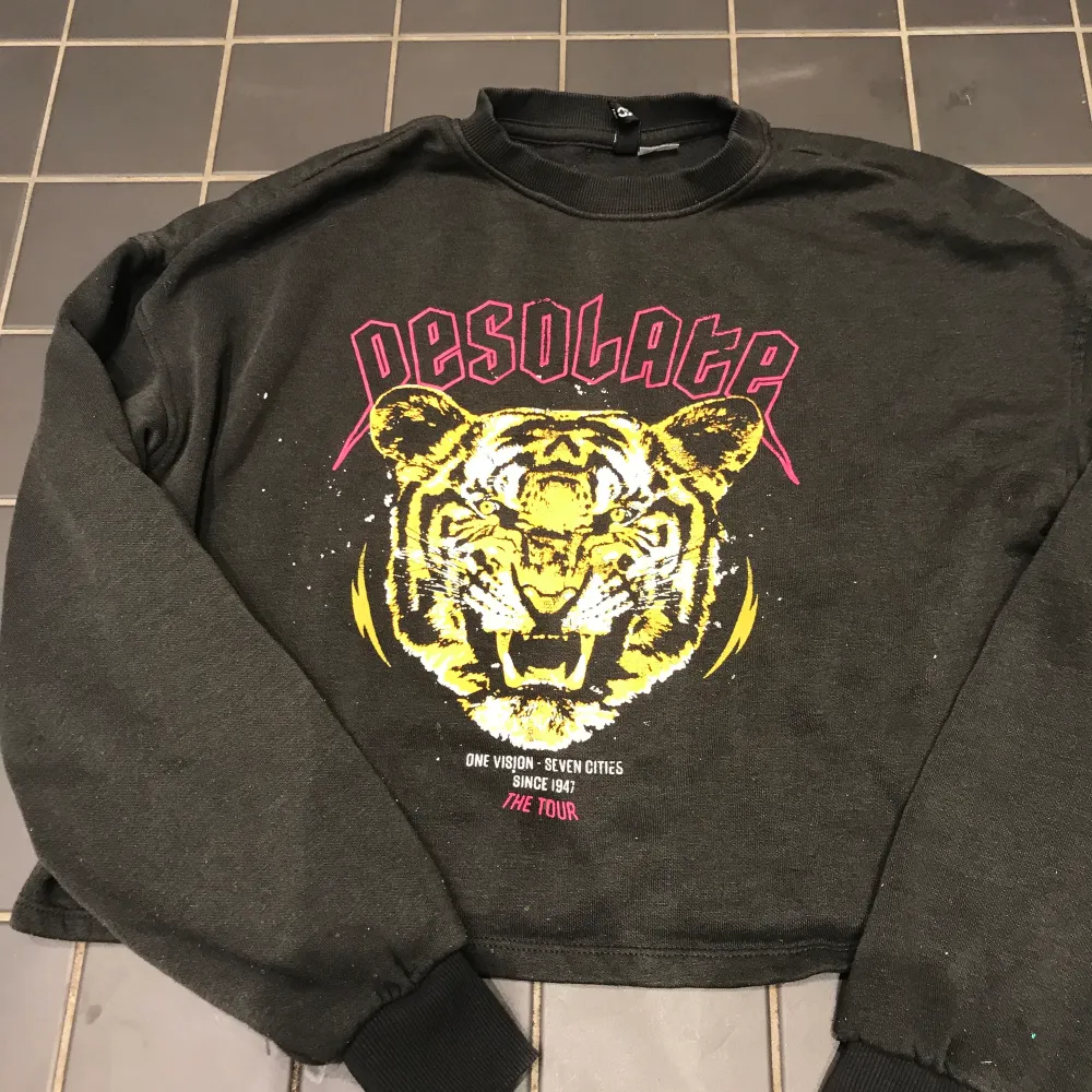 En svart croppad tröja från hm. I bra skick använt den 2-3 ggr.med en tiger bild . Hoodies.