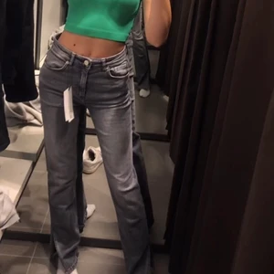 Zara midrisejeans  - INTRESSEKOLL på mina snygga midrise jeans, mörkgråa och har en slit längt ner. Helt nya, säljer endast vid bra bud. Jag är 168!