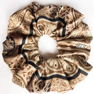 En beige-brun-koppar scrunchie sydd av en vintagesjal. Supermjuk och håller håret uppe bra. 