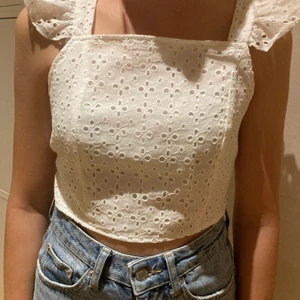 Spetsig sommar top - Det är en vit spetsig top med volanger på axlarna. Där bak har den ett knyte så man kan ändra själv. Den är kortare i magen. Toppen kommer i från shein och är i storlek S. Den är aldrig använd så helt splitter ny. 