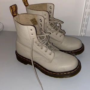 Dr. Martens skor  - Säljer mina beige/gråa dr. Martens stövlar. Den ena skon har ytterst lite rispor som bilden visar, men annars är dom som nya. Dom är i storlek 38 och kostar 500kr