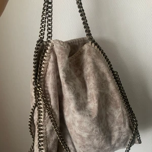 Stella McCartney liknande väska - Säljer min Stella McCartney liknande väska då den inte kommer till användning längre. Färgen är superfin men ganska svår att få på bild men den är ljusrosa/grå aktig! Fler bilder kan skickas vid intresse! 