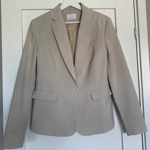Grå-beige kavaj - Säljer denna fina grå/beige-färgade kavajen som jag köpt second hand. Står ingen storlek i men jag skulle säga att det är en S. Bilderna gör inte riktigt färgen rättvisa så fråga gärna om fler bilder om du är intresserad!:) 