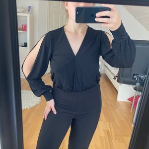 Topp (body) - Svart topp i bodymodell från NLYOne med öppning på ärmarna. Har sytt ihop vid urringningen då jag tyckte den var för urringad men går säkert att ta bort om man vill det! Endast använd två gånger så är i fint skick!