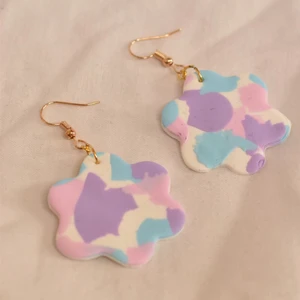 Färgglada örhängen- nr 17 - Vit bakgrund med lila, blå och rosa mönster. Handgjorda örhängen utav polymer lera med guldhänge, 3-4 cm i diamanter. 79kr + 20kr frakt 